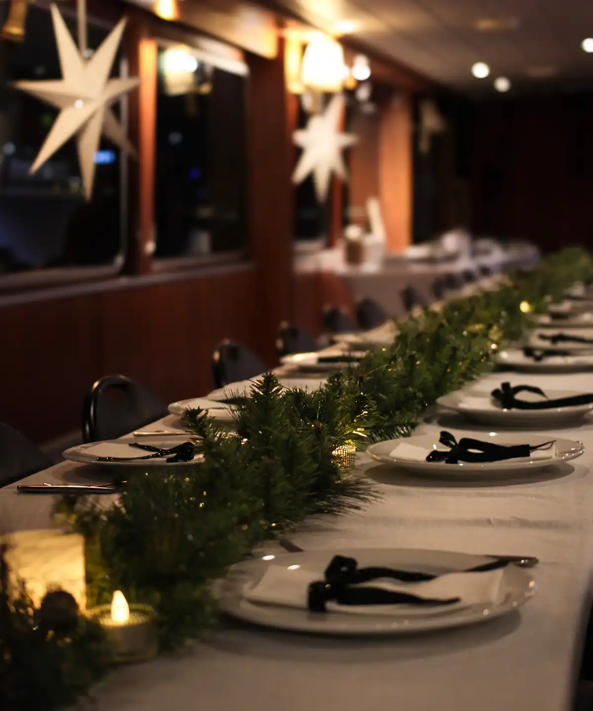 Christmas decorated long tables in the boat's saloon with poinsettias in the window.